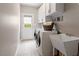 Functional laundry room with modern appliances, a utility sink, storage cabinets, and access to the outside at 2941 Grandview Heights Lane Ln, Raleigh, NC 27614