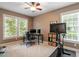 Home office with large windows, an ergonomic chair, and a dedicated fitness area with stationary bike at 2941 Grandview Heights Lane Ln, Raleigh, NC 27614