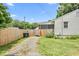 Spacious backyard featuring a gravel driveway, fenced perimeter, and well-maintained lawn at 302 Bradley St, Burlington, NC 27215