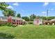 Wide backyard showcasing a large manicured lawn, sheds, and a wooden fence bordering the property at 302 Bradley St, Burlington, NC 27215