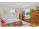 Bedroom with hardwood floors, closet and colorful floral-themed bedding at 302 Bradley St, Burlington, NC 27215