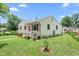 Quaint white home featuring pink shutters and a well-maintained front yard at 302 Bradley St, Burlington, NC 27215