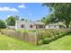 View of the cute white home with a pretty wooden fence and green, landscaped front yard at 302 Bradley St, Burlington, NC 27215