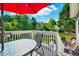 Back deck featuring a table with chairs and beautiful green backyard with blue skies above at 3217 Enchanting Way, Raleigh, NC 27616