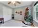 Light bedroom showcasing a Christmas tree, closet, and window at 3217 Enchanting Way, Raleigh, NC 27616