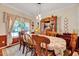 Elegant dining room featuring decorative china cabinet, carved wood chairs, and large window offering ample natural light at 3217 Enchanting Way, Raleigh, NC 27616