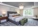 Elegant main bedroom featuring a large bed, stylish chandelier, and abundant natural light from large windows at 331 Bridle Brook Way, Fuquay Varina, NC 27526
