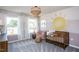 Bedroom featuring a wooden crib, whimsical decor, and two bright windows at 331 Bridle Brook Way, Fuquay Varina, NC 27526
