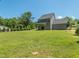 Spacious backyard with lush green grass and a view of the house with gray siding at 335 Glenn St, Franklinton, NC 27525