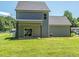 View of the home's gray siding, backyard patio, and expansive green lawn at 335 Glenn St, Franklinton, NC 27525