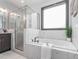 Bright bathroom featuring a soaking tub with marble surround and a window for natural light at 335 Glenn St, Franklinton, NC 27525