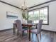 An elegant dining room with wood floors, gray upholstered chairs, natural light, and a stylish chandelier overhead at 335 Glenn St, Franklinton, NC 27525