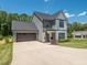 A spacious two-story home showcasing an attached garage and a meticulously maintained lawn in a tree-lined neighborhood at 335 Glenn St, Franklinton, NC 27525