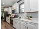 Bright kitchen with white cabinets, stainless steel appliances, and wood plank flooring at 335 Glenn St, Franklinton, NC 27525