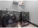 Modern laundry room featuring black front load washer and dryer on tile floors at 335 Glenn St, Franklinton, NC 27525