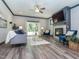 Comfortable living room featuring a fireplace, TV, ceiling fan, modern furniture, and sliding glass door leading outside at 335 Glenn St, Franklinton, NC 27525