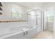 Bright bathroom featuring a soaking tub and a glass shower stall at 3504 Regent Pines Dr, New Hill, NC 27562