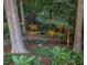 Serene backyard setting with mature trees, water feature, stone bench, and landscape lighting at 3606 Dairy Pond Pl, Durham, NC 27705