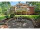 Exterior view of a two-story home features a stone patio with backyard views and manicured lawn at 3606 Dairy Pond Pl, Durham, NC 27705
