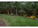 Expansive backyard with lush lawn, mature trees, and carefully manicured landscaping and lighting at 3606 Dairy Pond Pl, Durham, NC 27705