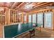 Unfinished basement features exposed wooden beams, concrete floor, and ping pong table with access to the backyard at 3606 Dairy Pond Pl, Durham, NC 27705
