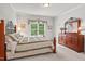Comfortable bedroom with a decorative bed frame, soft carpet, and large window with backyard view at 3606 Dairy Pond Pl, Durham, NC 27705