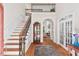 Bright foyer with hardwood floors, staircase with decorative iron railing and arched doorways at 3606 Dairy Pond Pl, Durham, NC 27705