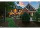 Elegant brick home with manicured landscaping, illuminated windows, and a welcoming entrance at twilight at 3606 Dairy Pond Pl, Durham, NC 27705