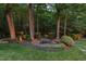 Backyard patio with a round table, chairs, lush landscaping, and mature trees at 3606 Dairy Pond Pl, Durham, NC 27705