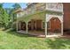 Lower patio of a two-story home with brick pillars and decorative lattice offers views of the backyard at 3606 Dairy Pond Pl, Durham, NC 27705