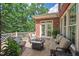 Outdoor patio with comfortable seating and a fire pit, complemented by a view of the tree-lined backyard at 3606 Dairy Pond Pl, Durham, NC 27705