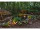 Backyard features a pond with a gentle fountain, framed by lush greenery and landscape lighting at 3606 Dairy Pond Pl, Durham, NC 27705