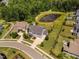 Aerial view of home with mature trees, green lawn, and a neighborhood pond view at 408 Brierley Dr, Apex, NC 27523