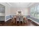 Elegant dining room with hardwood floors, wainscoting, shutters, modern chandelier and dining table at 408 Brierley Dr, Apex, NC 27523