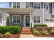 Inviting front porch featuring classic columns, brick steps, lush landscaping, and decorative wreath on the door at 408 Brierley Dr, Apex, NC 27523