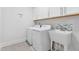 This laundry room features white walls, a tile floor, washer, dryer, cabinets and sink at 408 Brierley Dr, Apex, NC 27523