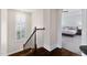 Upstairs hallway with staircase and view into a carpeted bedroom with a ceiling fan at 408 Brierley Dr, Apex, NC 27523