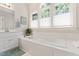 Bright bathroom with a soaking tub beneath a trio of sunny windows at 4309 Omni Pl, Raleigh, NC 27613