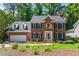 Charming two-story brick home with manicured lawn and blue shutters surrounded by lush greenery at 4309 Omni Pl, Raleigh, NC 27613