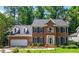 Charming two-story brick home with blue shutters, a well-manicured lawn, and lush landscaping at 4309 Omni Pl, Raleigh, NC 27613
