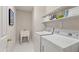 Bright laundry room with sink, washer, dryer, and overhead storage shelves at 4309 Omni Pl, Raleigh, NC 27613