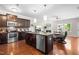 Open-concept kitchen with a granite island, stainless steel appliances, and dark wood cabinets at 437 Excalibur Dr, Morrisville, NC 27560
