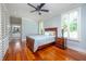 Bedroom with wood floors, ceiling fan, a bed with blue quilt, and white plantation shutters at 4412 Pamlico Dr, Raleigh, NC 27609