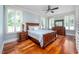 Bedroom with wood floors, plantation shutters, ceiling fan, and a bed with blue quilt at 4412 Pamlico Dr, Raleigh, NC 27609