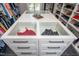 Custom closet island with glass display cases, drawers, and stylish hardware provides ample storage space at 4412 Pamlico Dr, Raleigh, NC 27609