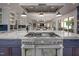 Open kitchen with professional-grade stove, ample marble counters, island and stainless hood at 4412 Pamlico Dr, Raleigh, NC 27609