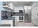 A modern kitchen featuring white cabinets, stainless steel appliances, and granite countertops at 4412 Pamlico Dr, Raleigh, NC 27609
