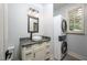 Well-lit laundry room with stackable washer and dryer and modern vanity with vessel sink at 4412 Pamlico Dr, Raleigh, NC 27609