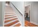 Hardwood staircase leading to the upper level, with a view into the laundry room on the side at 4412 Pamlico Dr, Raleigh, NC 27609