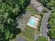 Aerial view of a community pool, lounge chairs, a tennis court, surrounded by trees and houses at 4600 Townesbury Ln, Raleigh, NC 27612